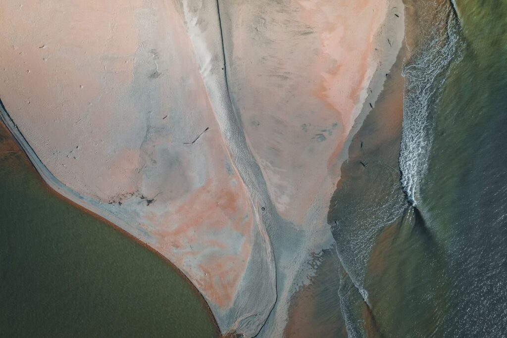 Aerial view of an estuary point, sandbar, and outgoing tidal currents