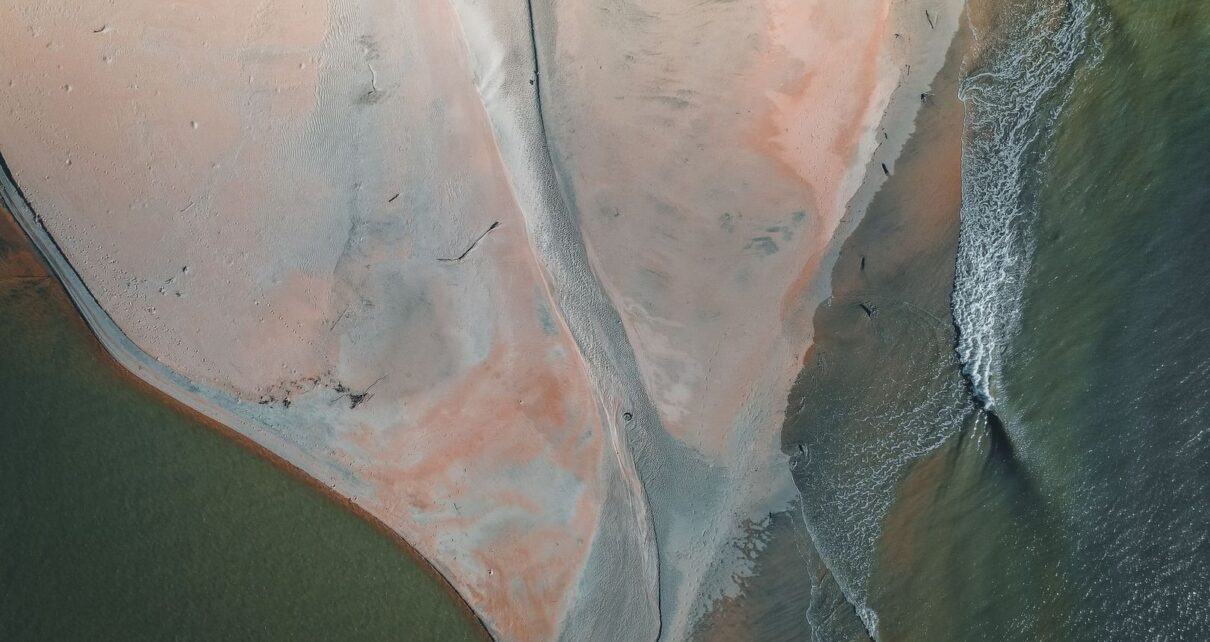 Aerial view of an estuary point, sandbar, and outgoing tidal currents