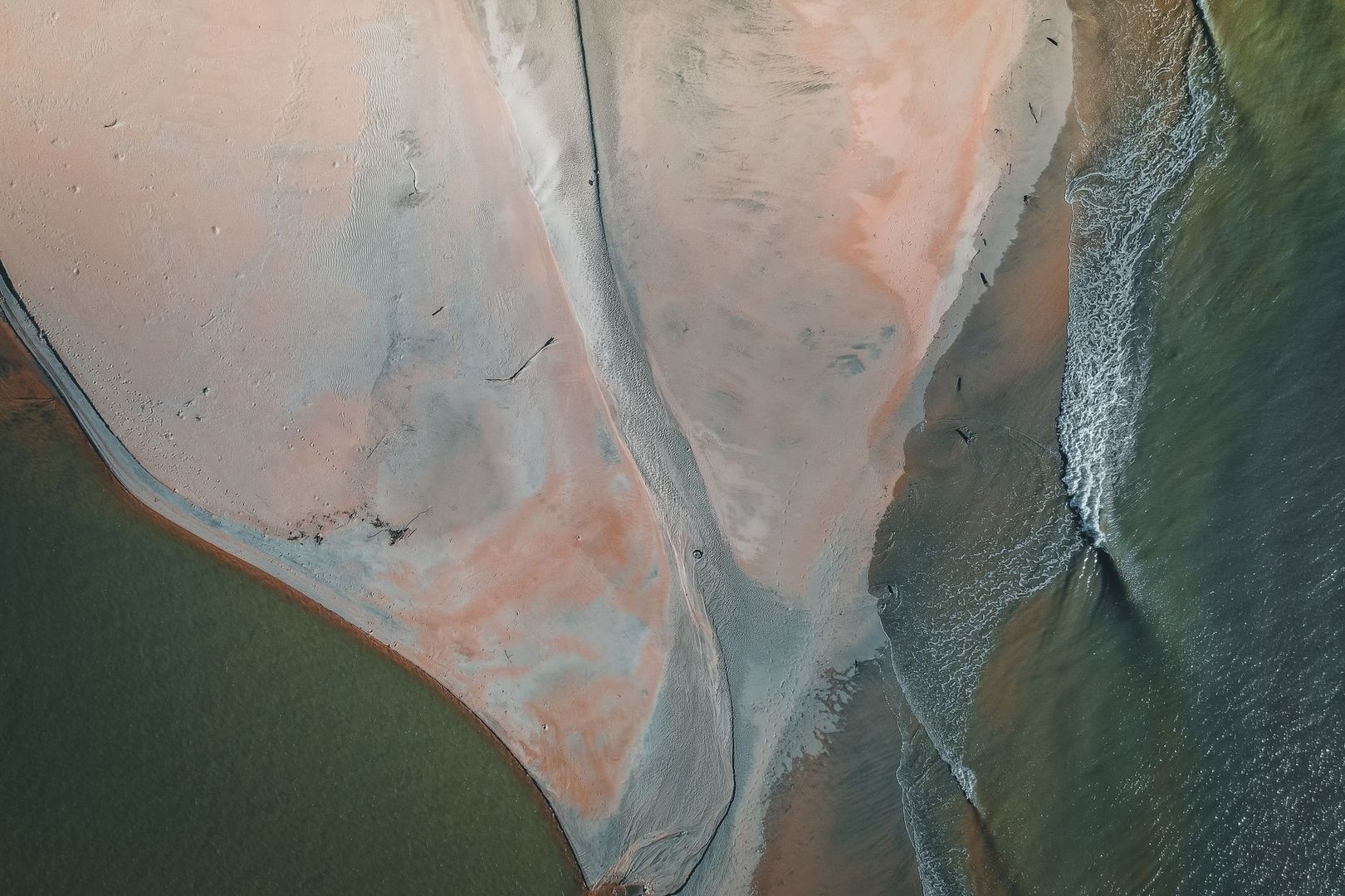 Aerial view of an estuary point, sandbar, and outgoing tidal currents